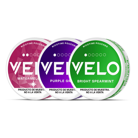 Tres latas redondas de VELO Mini Trial de VELO en color Sandía (rosa), Uva Morada (morado) y Menta Verde (verde) se muestran una al lado de la otra sobre un fondo blanco, con etiquetas en inglés y español.