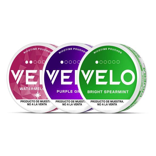 Tres latas redondas de VELO Mini Trial de VELO en color Sandía (rosa), Uva Morada (morado) y Menta Verde (verde) se muestran una al lado de la otra sobre un fondo blanco, con etiquetas en inglés y español.