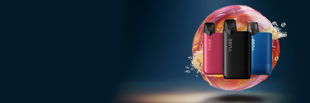 Tres dispositivos de vapeo Vuse en rosa, negro y azul se encuentran en posición vertical frente a un fondo arremolinado y colorido con salpicaduras de líquido, sobre un fondo azul oscuro.