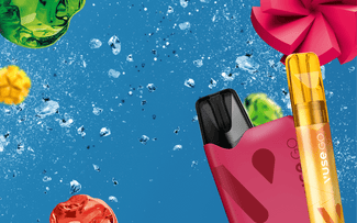 Aparatos de vapeo de colores brillantes con carcasas rojas y amarillas se muestran sobre un fondo azul con cubitos de hielo y decoraciones festivas y coloridas parecidas a caramelos o adornos.