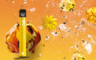 Un vaporizador amarillo en posición vertical sobre un fondo naranja, rodeado de cubitos de hielo flotantes, salpicaduras de líquido, dados de mango y un remolino de mango, que sugieren un sabor afrutado y refrescante.