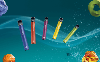 Cinco coloridos vapes desechables flotan en diagonal sobre un fondo verde azulado con efectos de luz arremolinada y formas abstractas de caramelo en las esquinas.