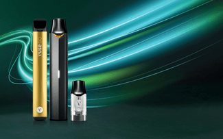 Tres elegantes dispositivos de vapeo -uno dorado, otro negro y una pequeña cápsula transparente- se muestran sobre un fondo verde oscuro con brillantes estelas de luz azul y verde.