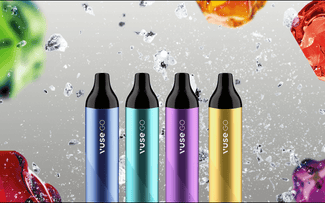 Cuatro bolígrafos para vapear Vuse GO en azul, verde azulado, morado y amarillo se colocan en posición vertical con salpicaduras de líquido y gotas de colores en el fondo.